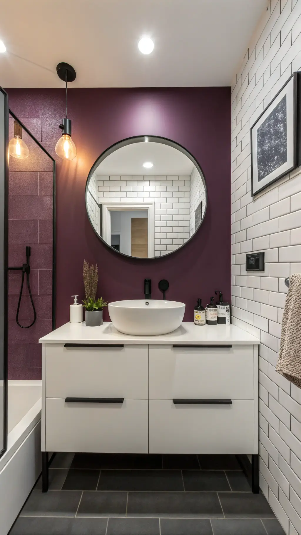 A modern urban apartment bathroom with color-blocked walls: the upper half in crisp white and the lower half in aubergine, featuring a matte white floating vanity, circular backlit mirror, matte black fixtures, geometric purple vessels, minimalist art, and clean-lined subway tiles in the shower.