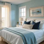 Photorealistic interior of a coastal bedroom featuring a king-size bed adorned with layered textures in warm morning light, pale aqua walls, sheer white curtains, and a natural jute rug, creating a serene and inviting atmosphere.