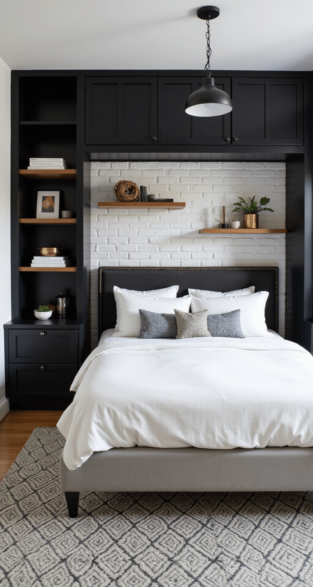 A compact 10x12ft bedroom with a white queen bed framed by floor-to-ceiling black built-ins, a geometric black and white area rug, a white brick accent wall with floating shelves, and mixed metal lighting fixtures, all illuminated by bright natural light and task lighting.