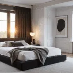 A luxurious black and white bedroom featuring a king platform bed with white linens and textured throw pillows, illuminated by golden hour sunlight through large windows, with modern furniture and minimalist decor accents.