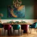 Cinematic interior photograph of an opulent dining room with emerald green walls, walnut dining table, brass chandelier, and jewel-toned velvet chairs, illuminated by warm golden hour light.