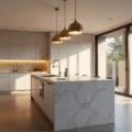 A luxurious modern kitchen featuring a marble island with brushed brass pendant lights, white matte cabinets with warm LED under-cabinet lighting, and Calacatta marble countertops, all illuminated by golden hour light streaming through large windows.