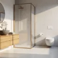 Photorealistic minimalist bathroom during golden hour, featuring white marble-effect tiles, bleached oak floating vanity, framed shower, oversized circular mirror, textured stone vessel sink, brushed brass fixtures, white orchid, and Turkish cotton towels.