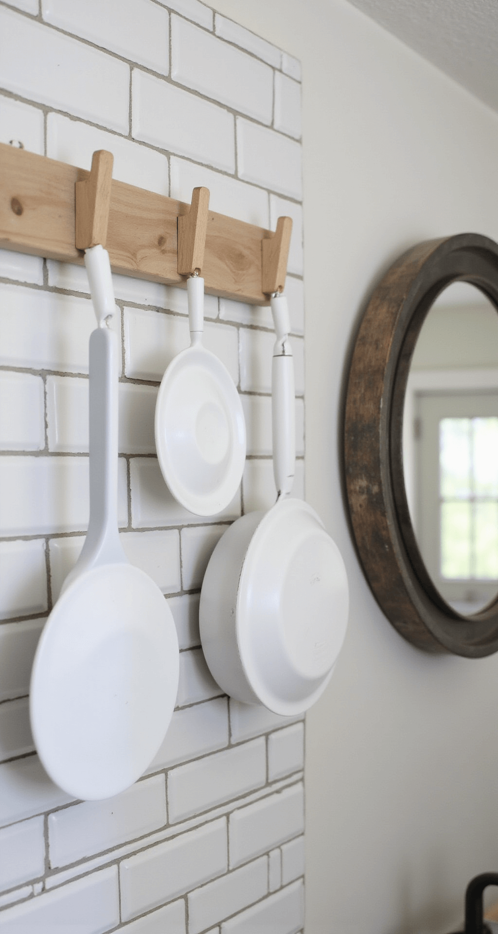 Close-up of budget-friendly organization solutions featuring painted clear bins, DIY wooden pegs holding cookware on a subway-tiled wall, and a large mirror reflecting morning light, with a soft bokeh effect.