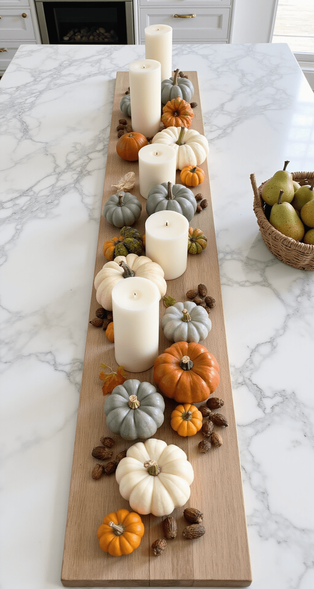 Simple Fall Decor Ideas That'll Make Your Home Pinterest-Worthy (Without Breaking the Bank) Overhead flat lay of a kitchen island styled for fall with mixed pumpkins, pillar candles, acorns, small gourds, and pears in a basket, set against a marble surface and white subway tiles.